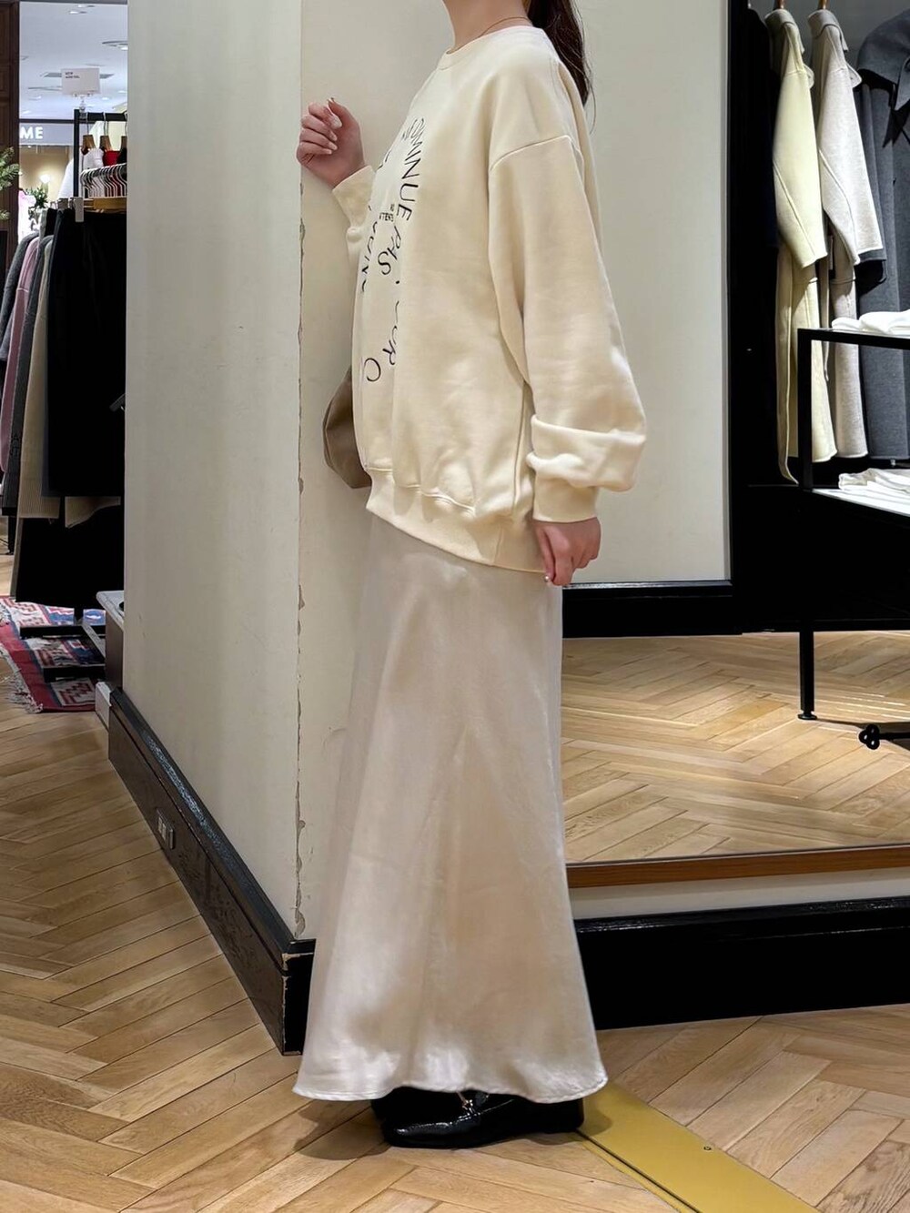 ブラック系のローファー、ホワイト系のスカート、ベージュ系のショルダーバッグを着用したレディースの冬コーディネートの3枚目の写真