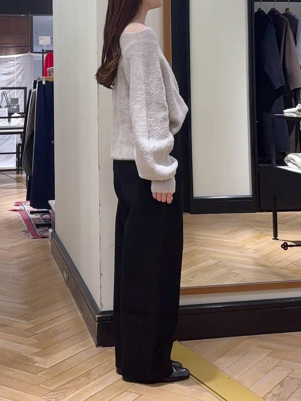 ブラック系のデニムパンツ、ブラック系のローファー、ブルー系のボストンバッグを着用したレディースの秋コーディネートの2枚目の写真