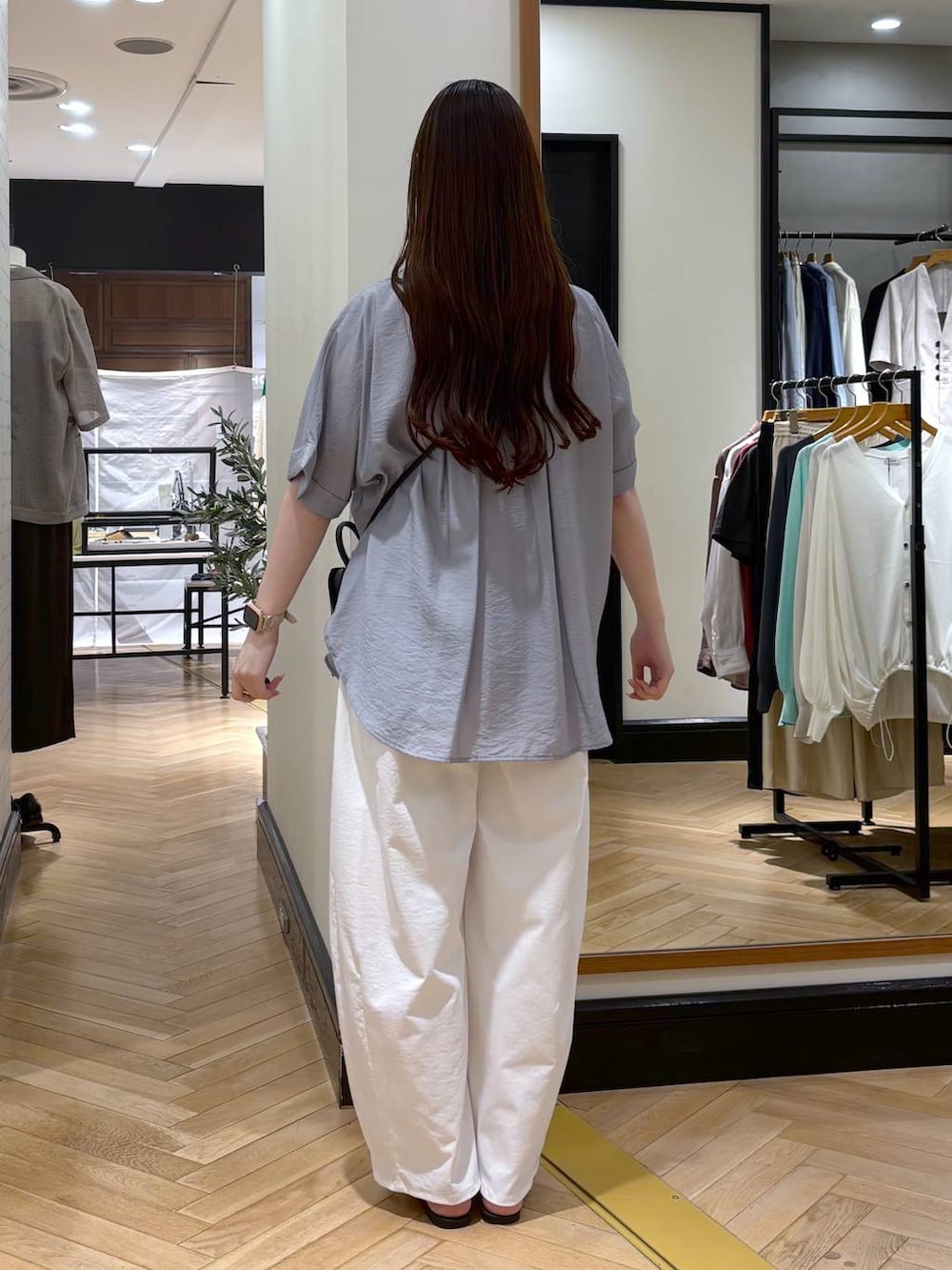 ブルー系のシャツ/ブラウス、ホワイト系のその他パンツ、ブラック系のショルダーバッグを着用したレディースの春コーディネートの4枚目の写真