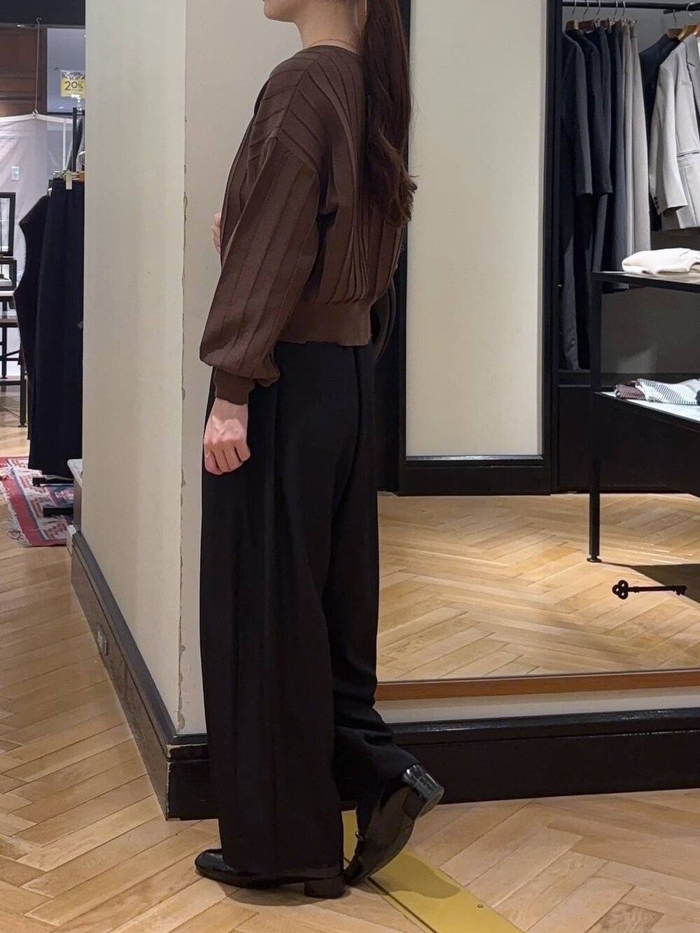 ブラック系のハンドバッグ、ブラウン系のカーディガン/ボレロ、ブラック系のローファーを着用したレディースの秋コーディネートの4枚目の写真