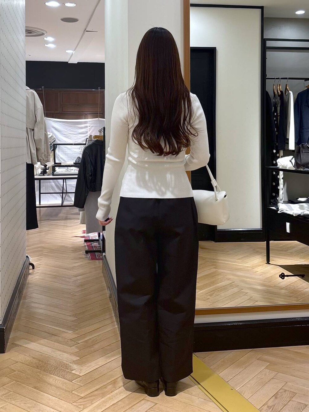 ブラック系のローファー、ホワイト系のカーディガン/ボレロ、ホワイト系のショルダーバッグを着用したレディースの春コーディネートの4枚目の写真