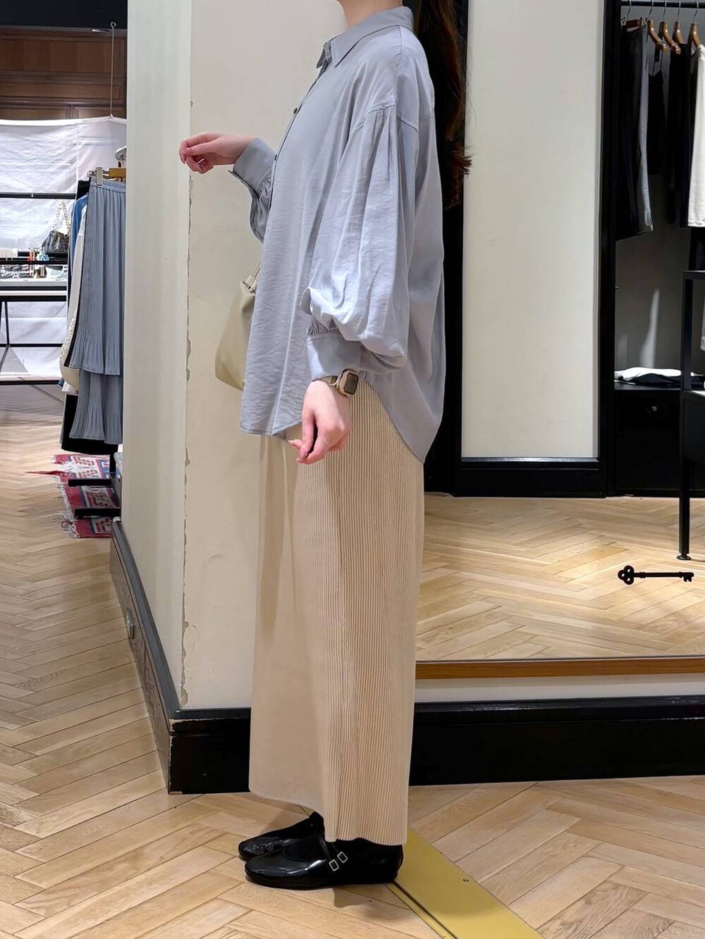 ホワイト系のスカート、ベージュ系のショルダーバッグ、ブルー系のシャツ/ブラウスを着用したレディースの春コーディネートの3枚目の写真