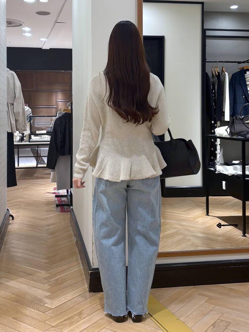 ブラック系のローファー、ブルー系のデニムパンツ、ブラック系のショルダーバッグを着用したレディースの春コーディネートの5枚目の写真