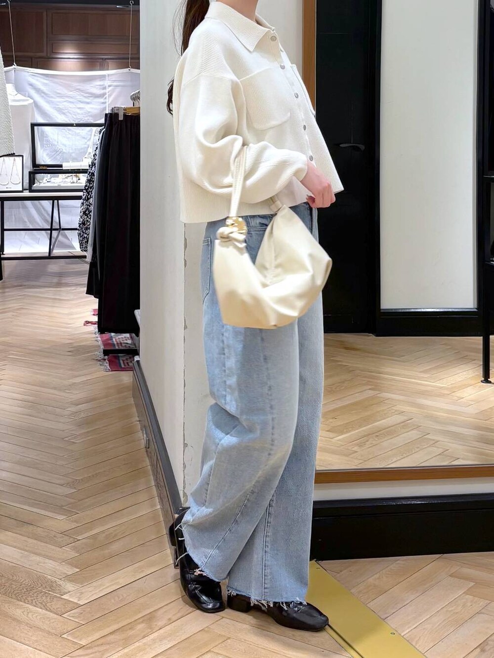 ブラック系のローファー、ブルー系のデニムパンツ、ホワイト系のカーディガン/ボレロを着用したレディースの冬コーディネートの2枚目の写真