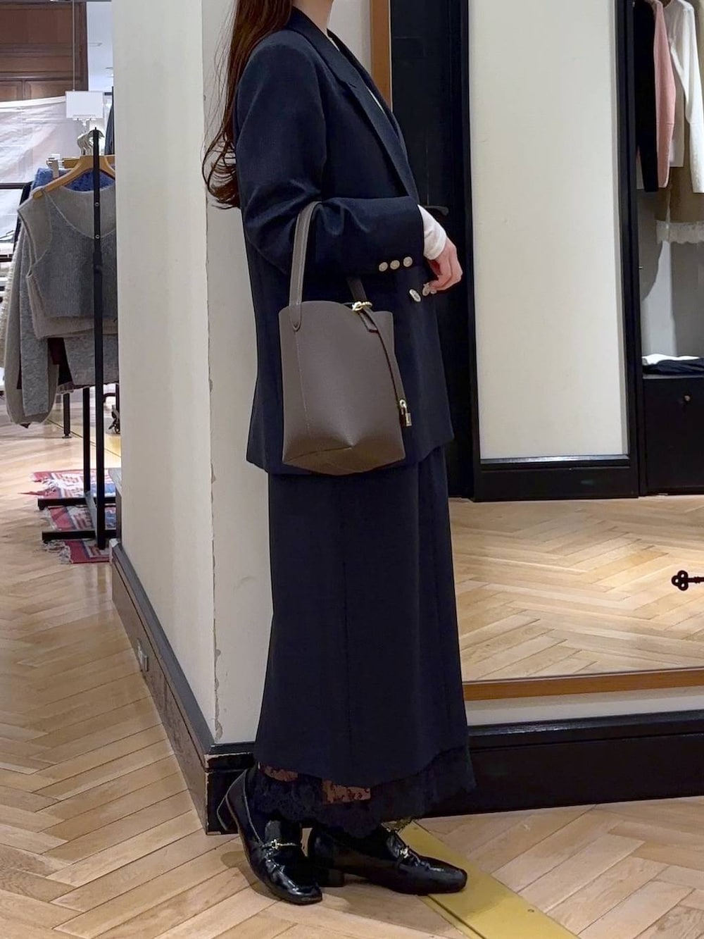 ブラック系のローファー、ブルー系のスカート、ブルー系のテーラードジャケットを着用したレディースの冬コーディネートの2枚目の写真