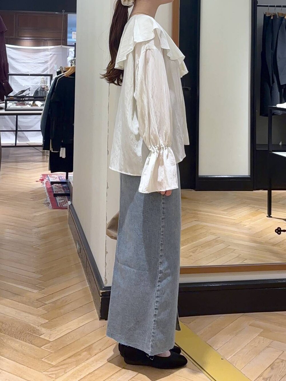 ブルー系のデニムスカート、ブラック系のバレエシューズ、ベージュ系のショルダーバッグを着用したレディースの秋コーディネートの5枚目の写真