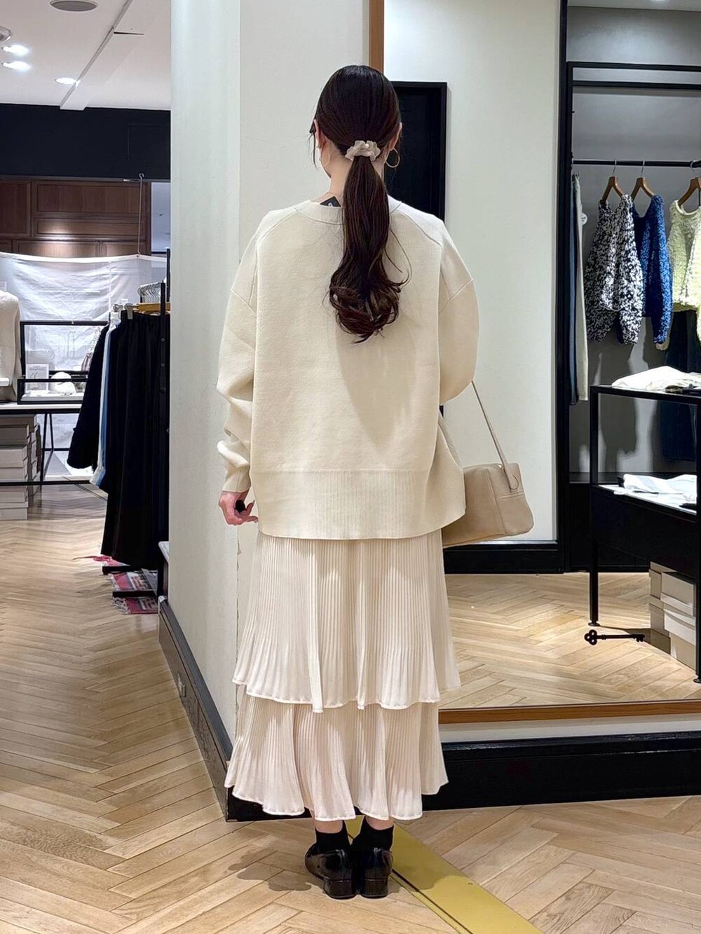 ホワイト系のスカート、ブラック系のローファー、ホワイト系のカーディガン/ボレロを着用したレディースの冬コーディネートの6枚目の写真