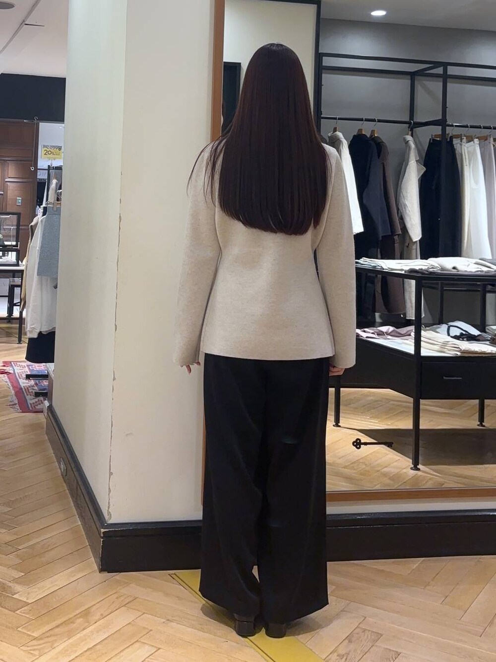 ブラック系のローファー、ブラック系のスラックス、ホワイト系のノーカラージャケットを着用したレディースの秋コーディネートの6枚目の写真