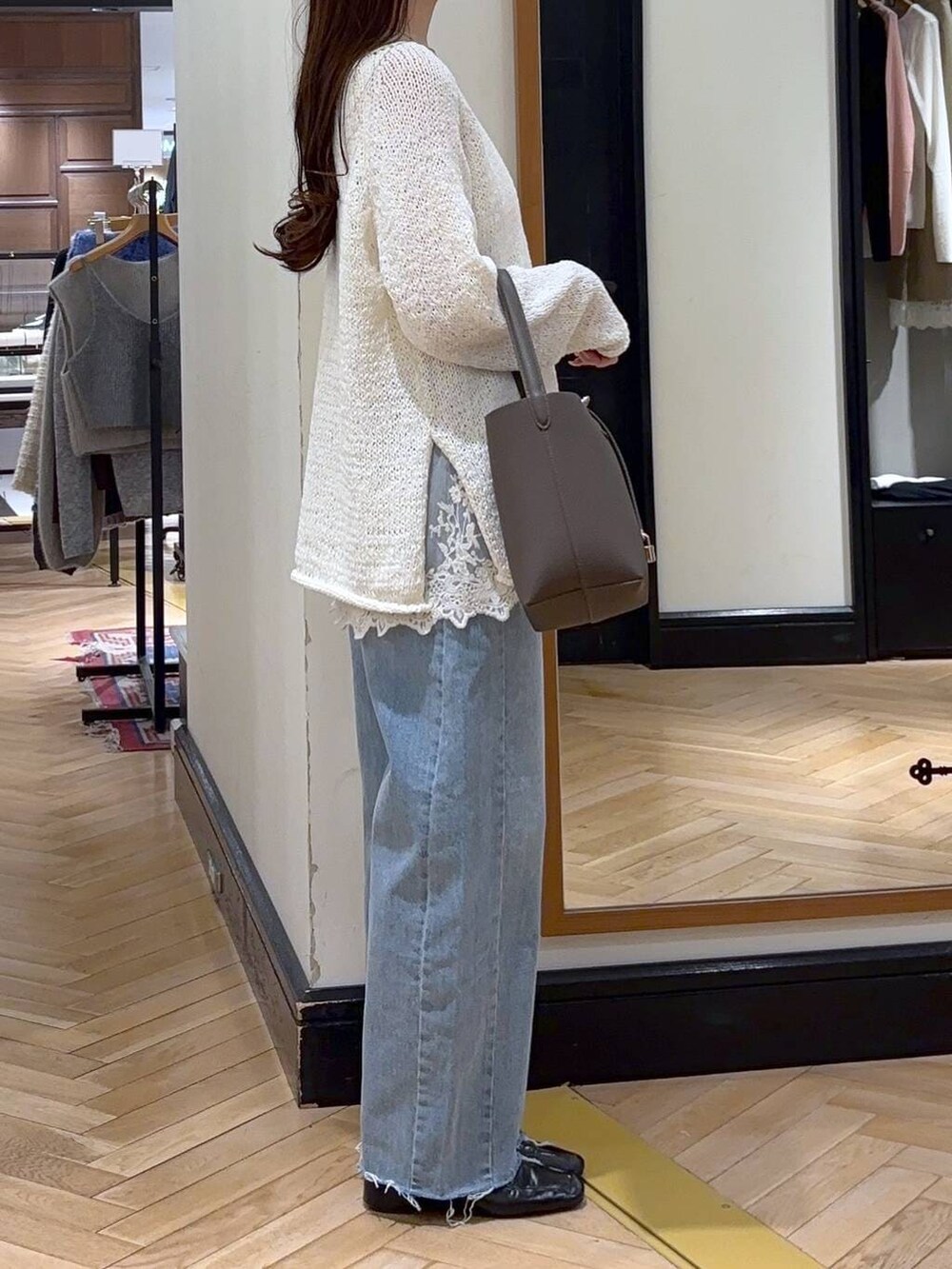 ブルー系のデニムパンツ、ブラック系のローファー、ホワイト系のキャミソールを着用したレディースの冬コーディネートの3枚目の写真