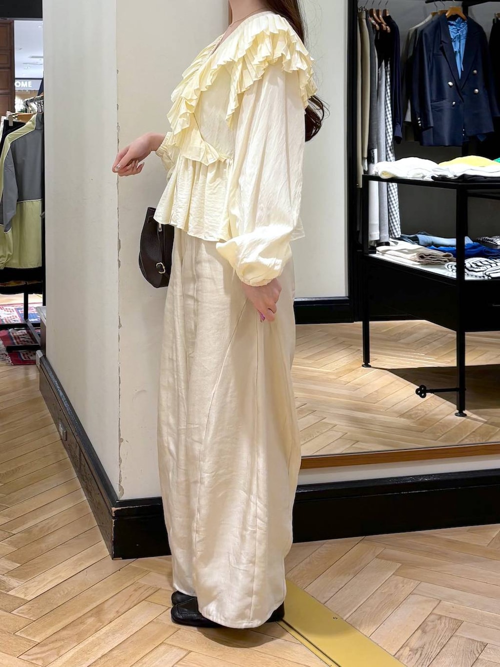 ブラック系のローファー、ホワイト系のその他パンツ、ブラウン系のショルダーバッグを着用したレディースの春コーディネートの3枚目の写真