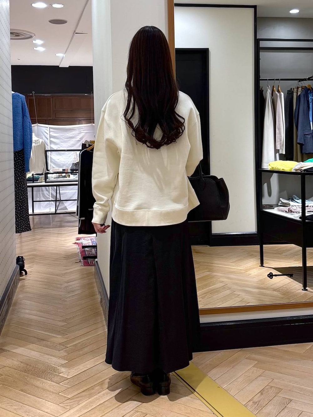 ブラック系のローファー、ブラック系のショルダーバッグ、ブラック系のスカートを着用したレディースの春コーディネートの3枚目の写真