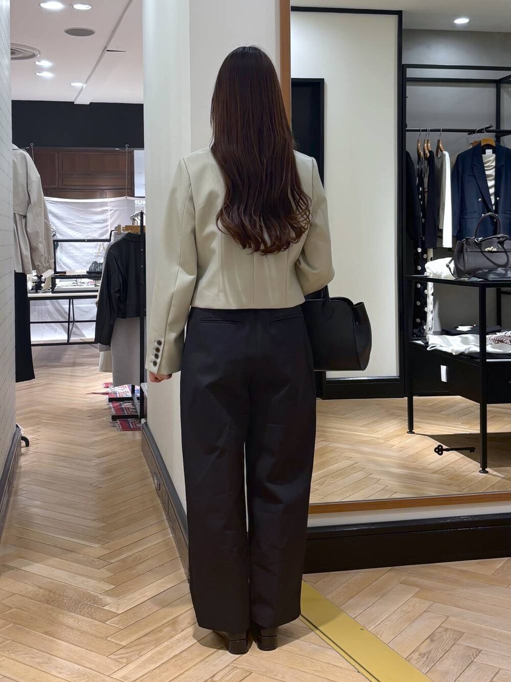 ブラック系のローファー、ブラック系のショルダーバッグ、ブラック系のチノパンツを着用したレディースの春コーディネートの4枚目の写真