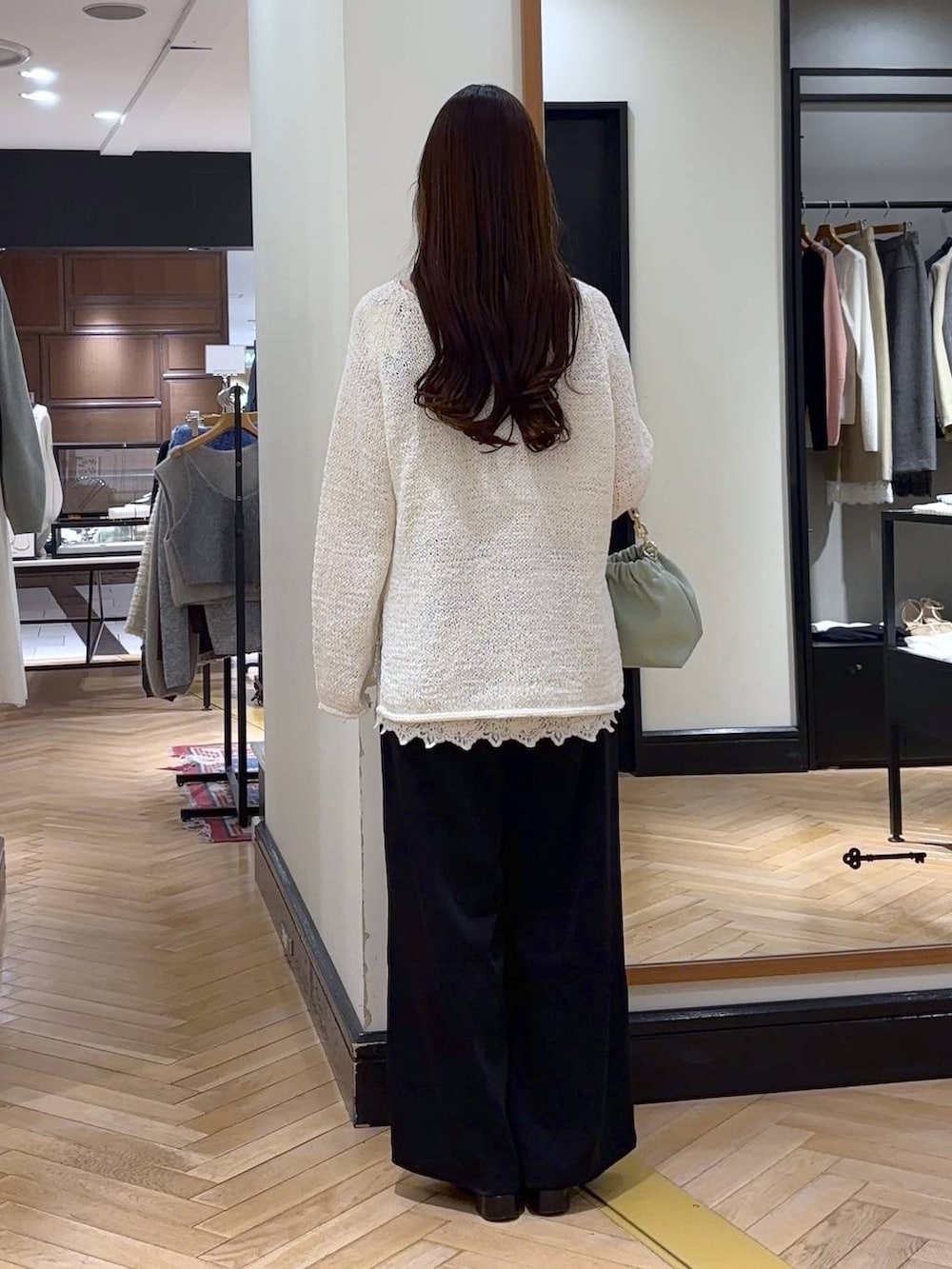 ブラック系のローファー、ブラック系のスラックス、グリーン系のショルダーバッグを着用したレディースの冬コーディネートの5枚目の写真