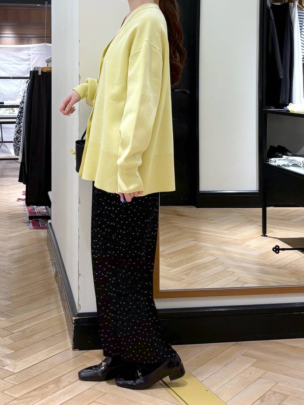 ブラック系のローファー、イエロー系のカーディガン/ボレロ、その他のスカートを着用したレディースの冬コーディネートの4枚目の写真