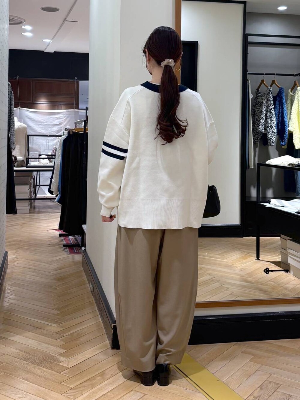 ベージュ系のスラックス、ブラック系のローファー、ブラック系のカーディガン/ボレロを着用したレディースの冬コーディネートの6枚目の写真