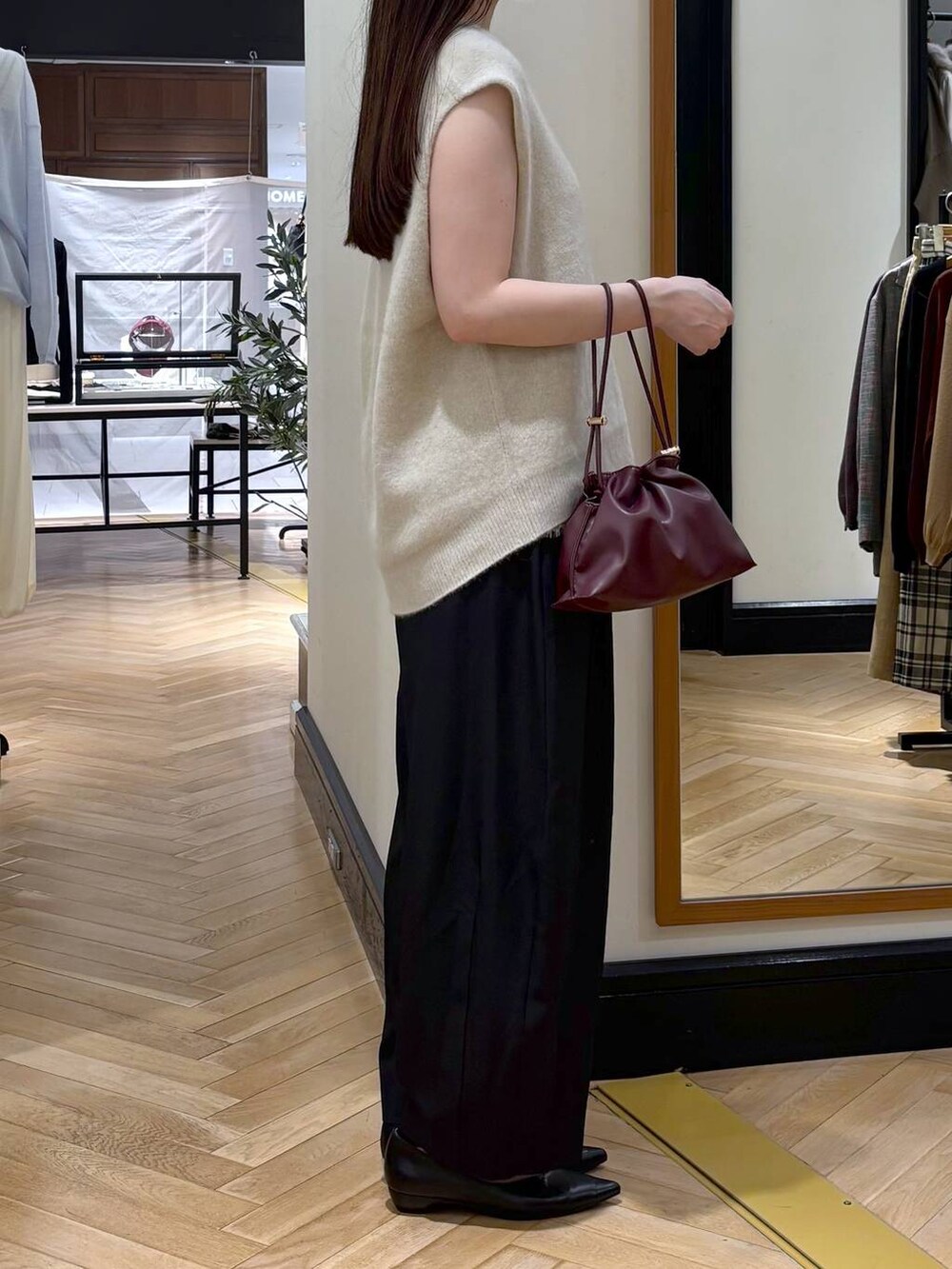 レッド系のショルダーバッグ、ブラック系のパンプス、ホワイト系のシャツ/ブラウスを着用したレディースの秋コーディネートの3枚目の写真
