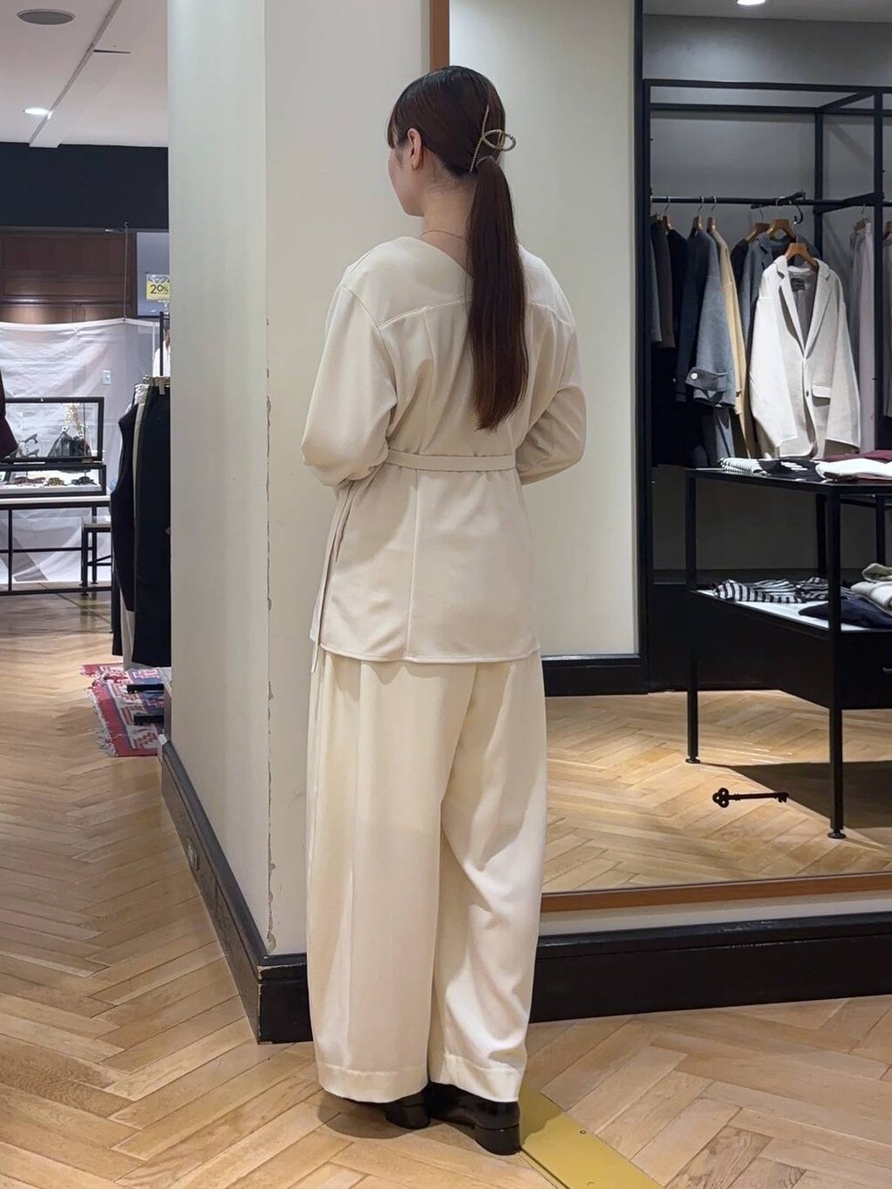 ホワイト系のスラックス、ブラック系のローファー、ブラック系のショルダーバッグを着用したレディースの秋コーディネートの5枚目の写真