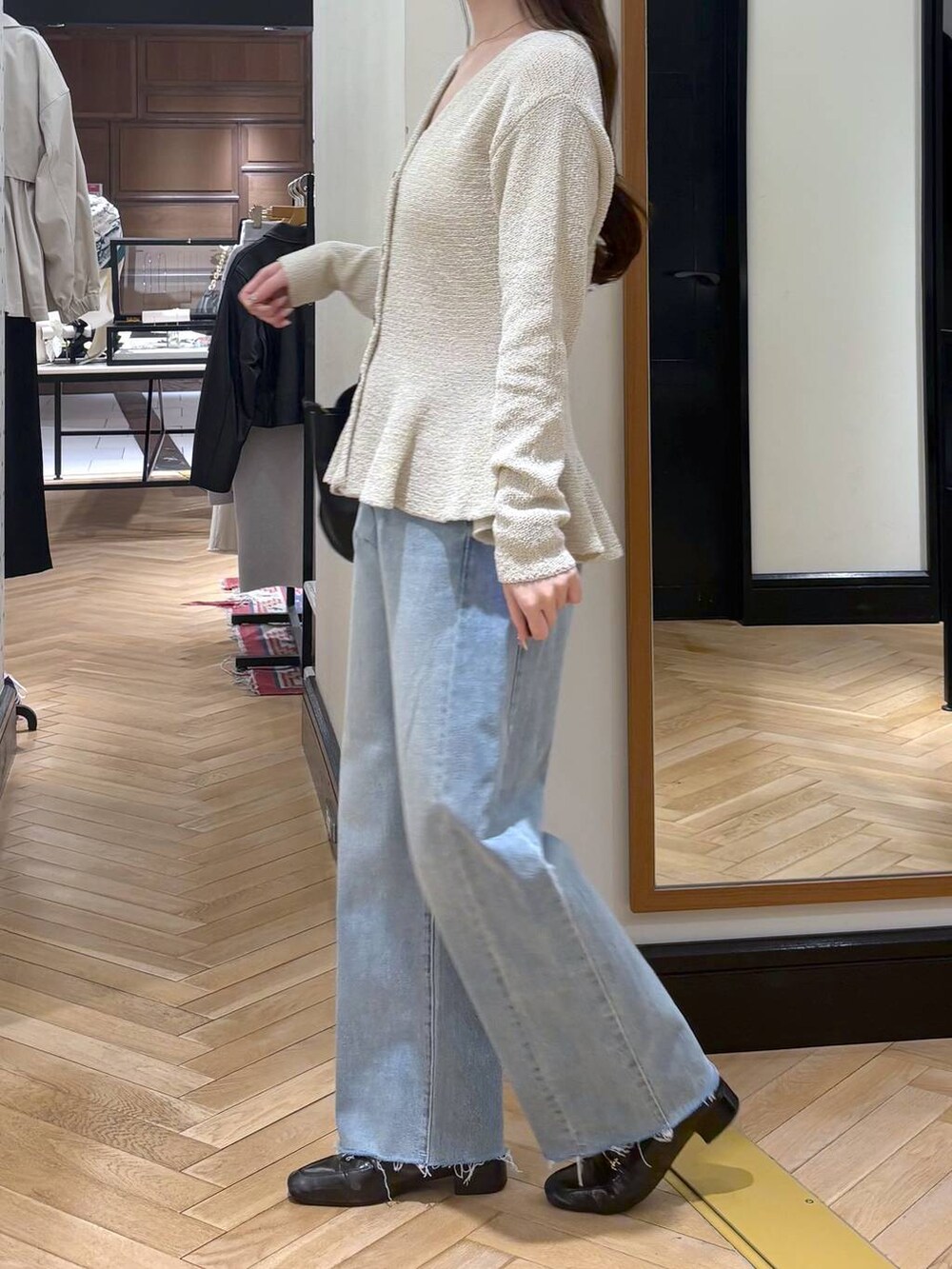 ブラック系のローファー、ブルー系のデニムパンツ、ブラック系のショルダーバッグを着用したレディースの春コーディネートの4枚目の写真