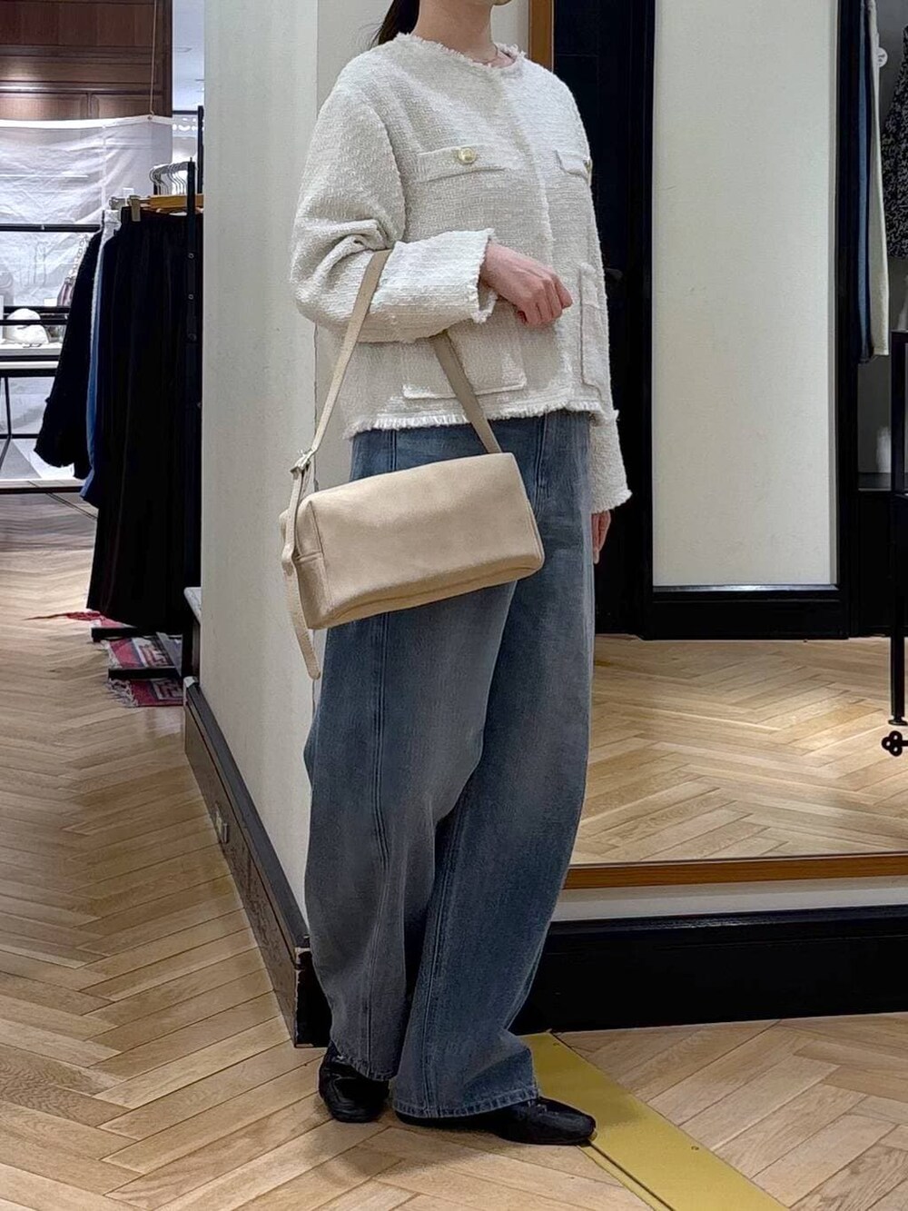 ブルー系のデニムパンツ、ブラック系のローファー、ホワイト系のノーカラージャケットを着用したレディースの冬コーディネートの2枚目の写真