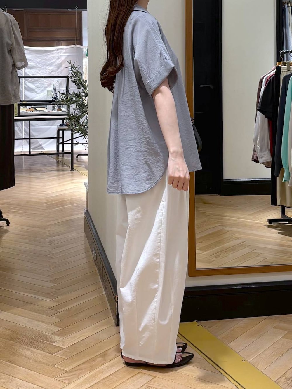 ブルー系のシャツ/ブラウス、ホワイト系のその他パンツ、ブラック系のショルダーバッグを着用したレディースの春コーディネートの2枚目の写真