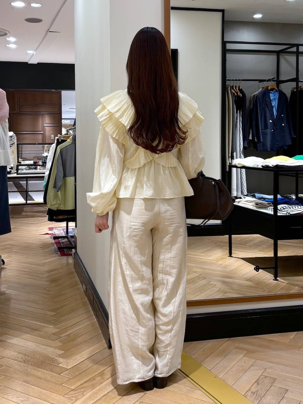 ブラック系のローファー、ホワイト系のその他パンツ、ブラウン系のショルダーバッグを着用したレディースの春コーディネートの4枚目の写真