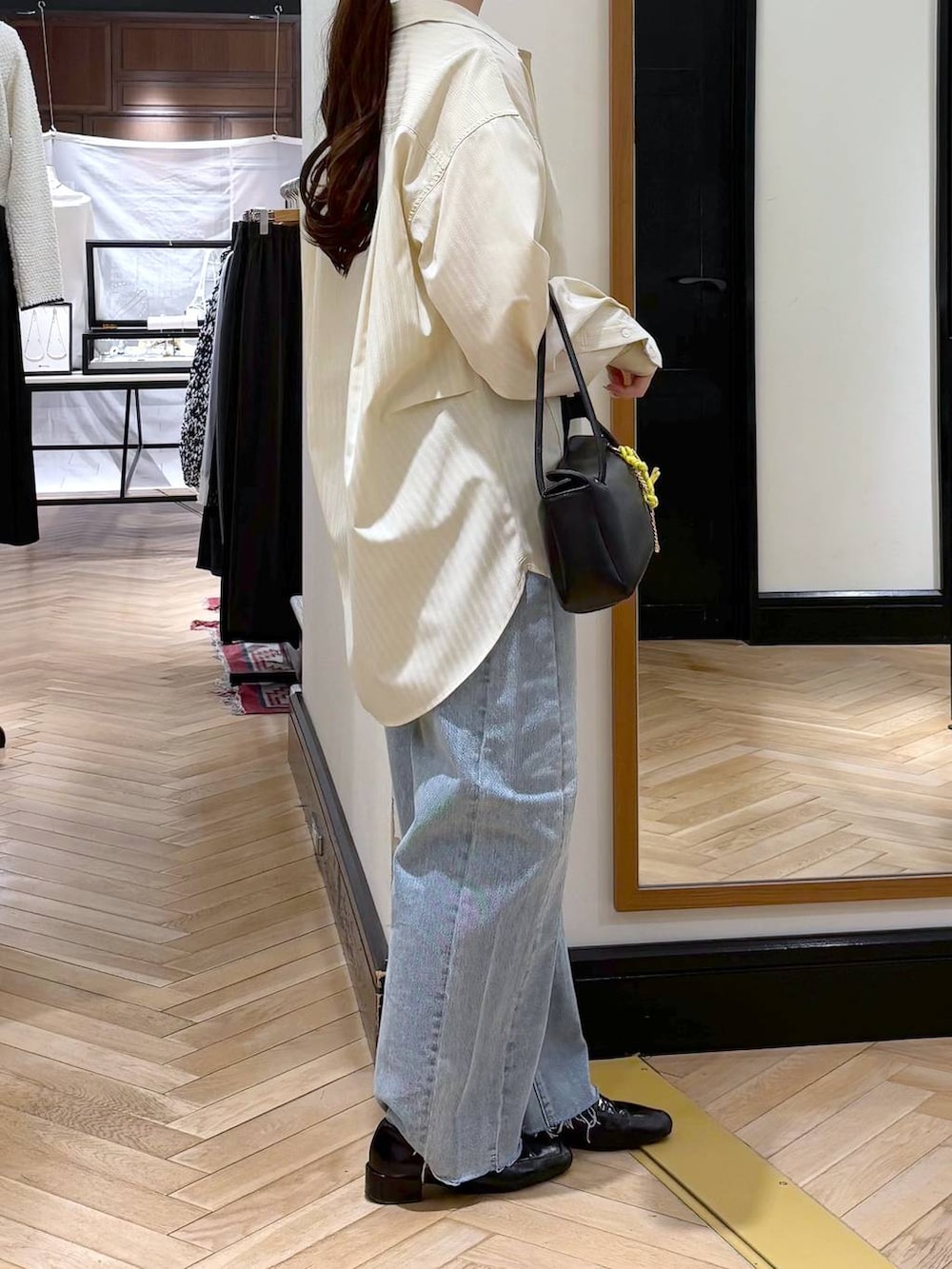 ブラック系のローファー、ブルー系のデニムパンツ、イエロー系のシャツ/ブラウスを着用したレディースの冬コーディネートの3枚目の写真