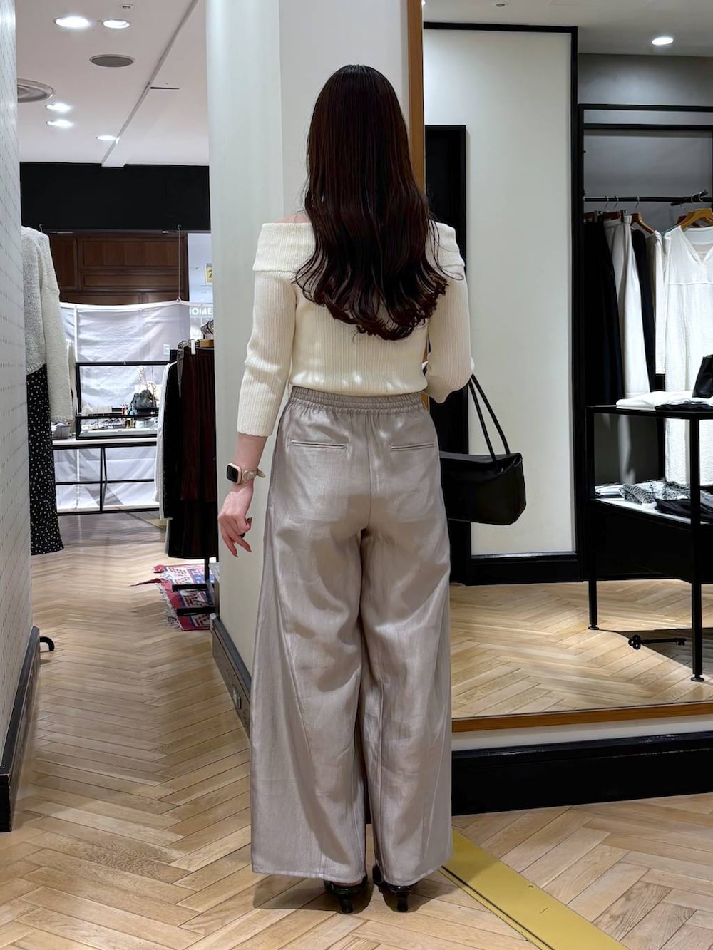 グレー系のその他パンツ、ブラック系のショルダーバッグ、ホワイト系のニット/セーターを着用したレディースの春コーディネートの4枚目の写真