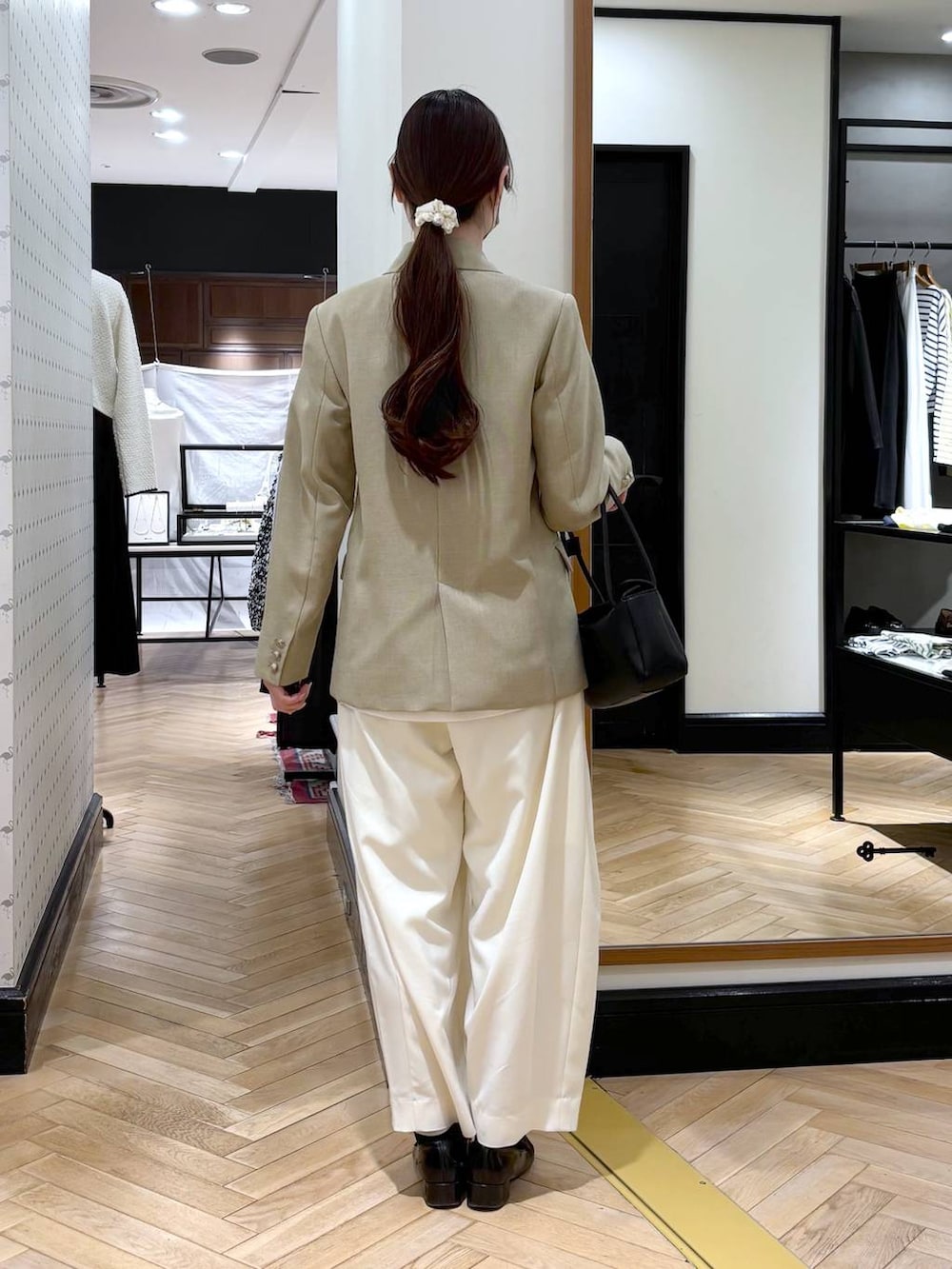 ホワイト系のスラックス、ブラック系のローファー、ベージュ系のテーラードジャケットを着用したレディースの冬コーディネートの4枚目の写真