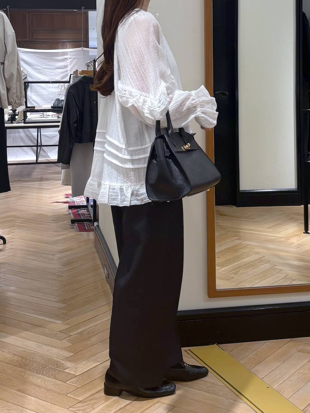 ブラック系のローファー、ブラック系のショルダーバッグ、ホワイト系のシャツ/ブラウスを着用したレディースの春コーディネートの3枚目の写真