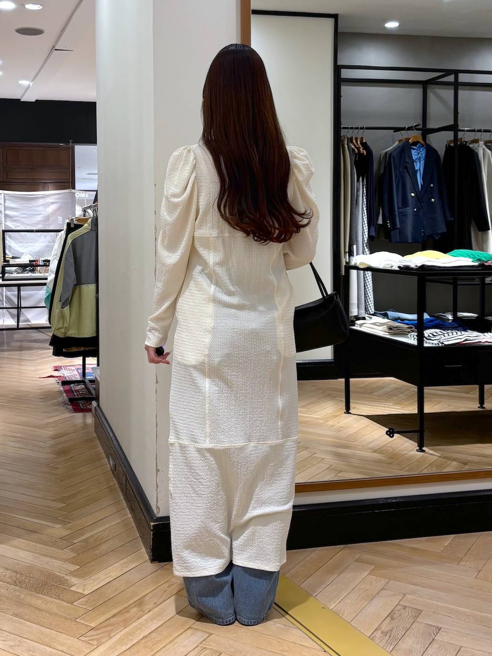 ブルー系のデニムパンツ、ブラック系のローファー、ブラック系のショルダーバッグを着用したレディースの春コーディネートの4枚目の写真