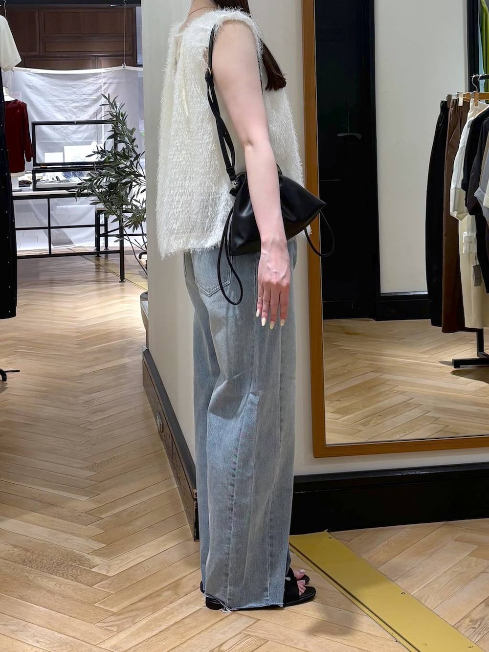 ブラック系のショルダーバッグ、ホワイト系のシャツ/ブラウス、ブルー系のデニムパンツを着用したレディースの夏コーディネートの2枚目の写真