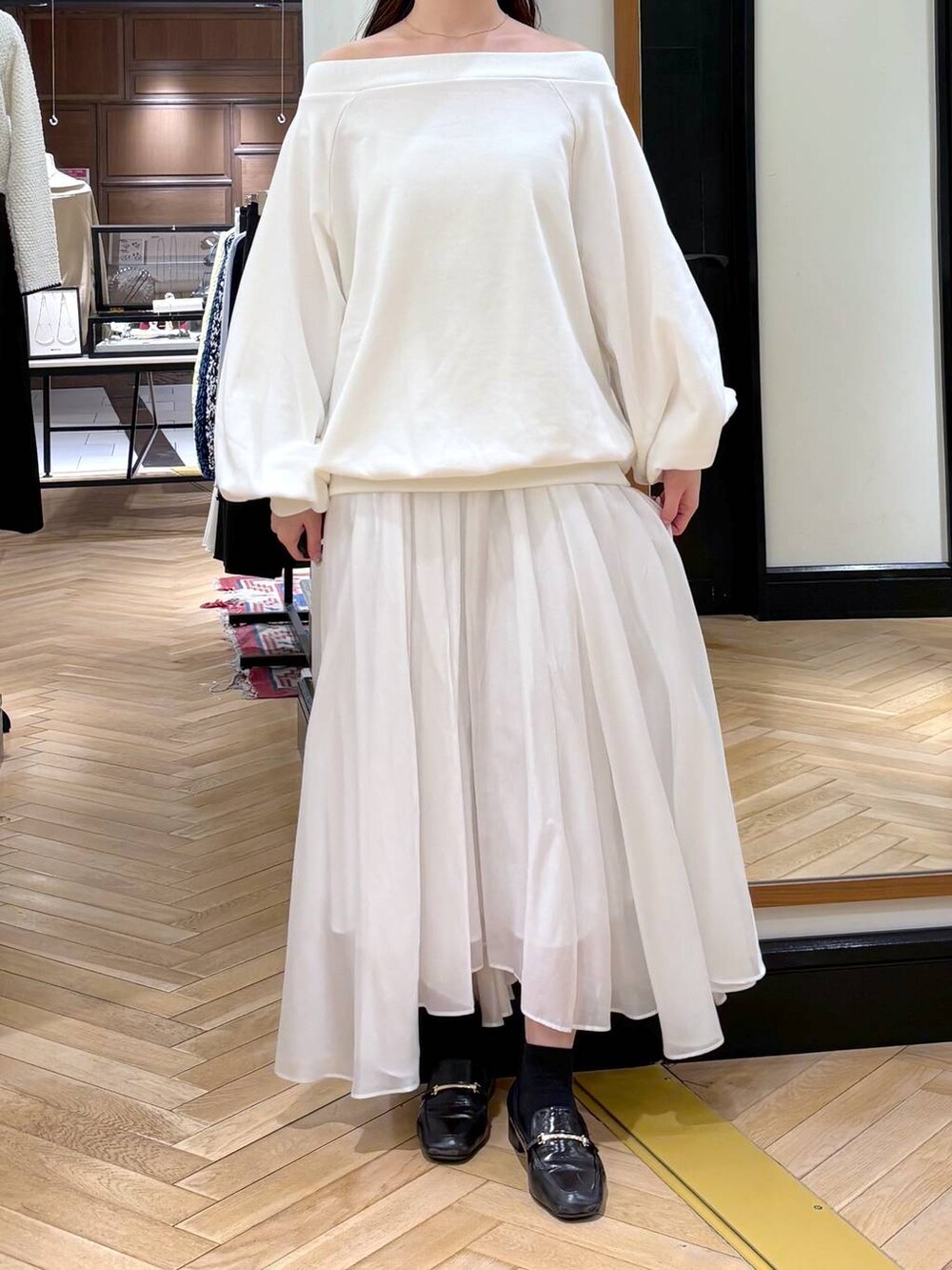 ブラック系のローファー、ホワイト系のスカート、ホワイト系のスウェットを着用したレディースの冬コーディネートの6枚目の写真