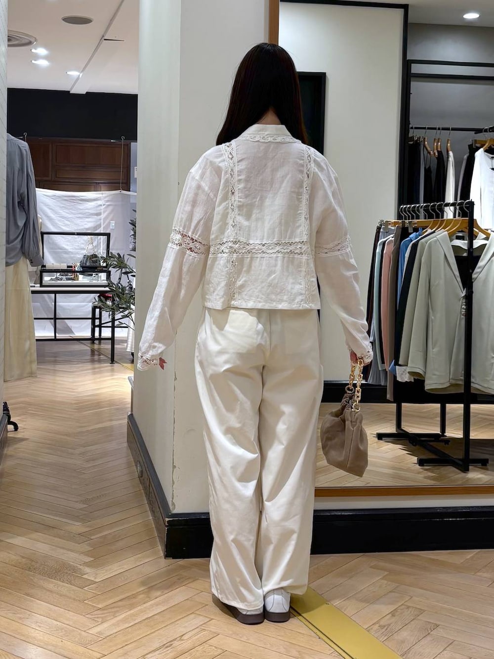 ベージュ系のショルダーバッグ、ホワイト系のスラックス、ホワイト系のシャツ/ブラウスを着用したレディースの春コーディネートの4枚目の写真