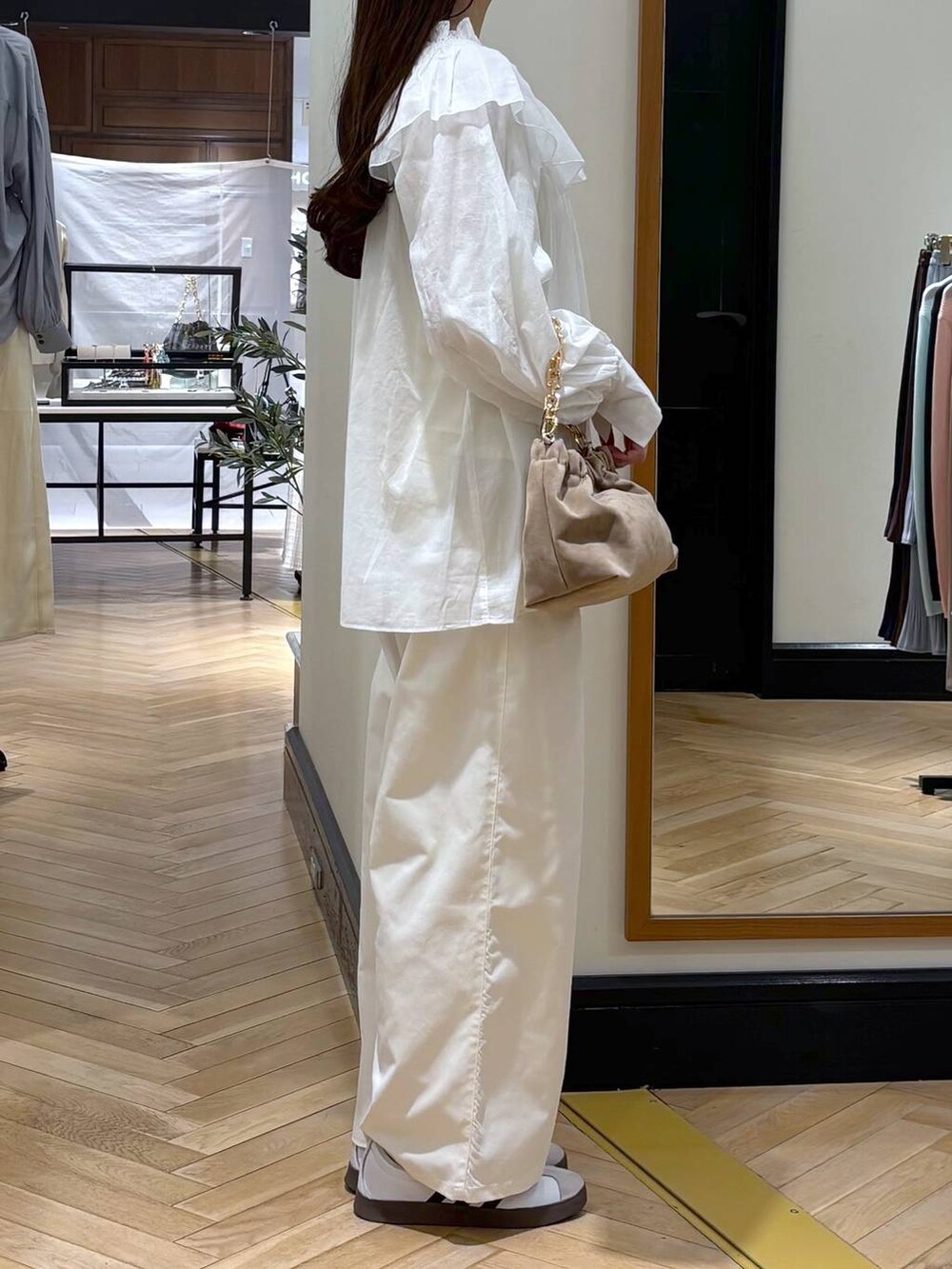 ベージュ系のショルダーバッグ、ホワイト系のTシャツ/カットソー、ホワイト系のスラックスを着用したレディースの春コーディネートの2枚目の写真