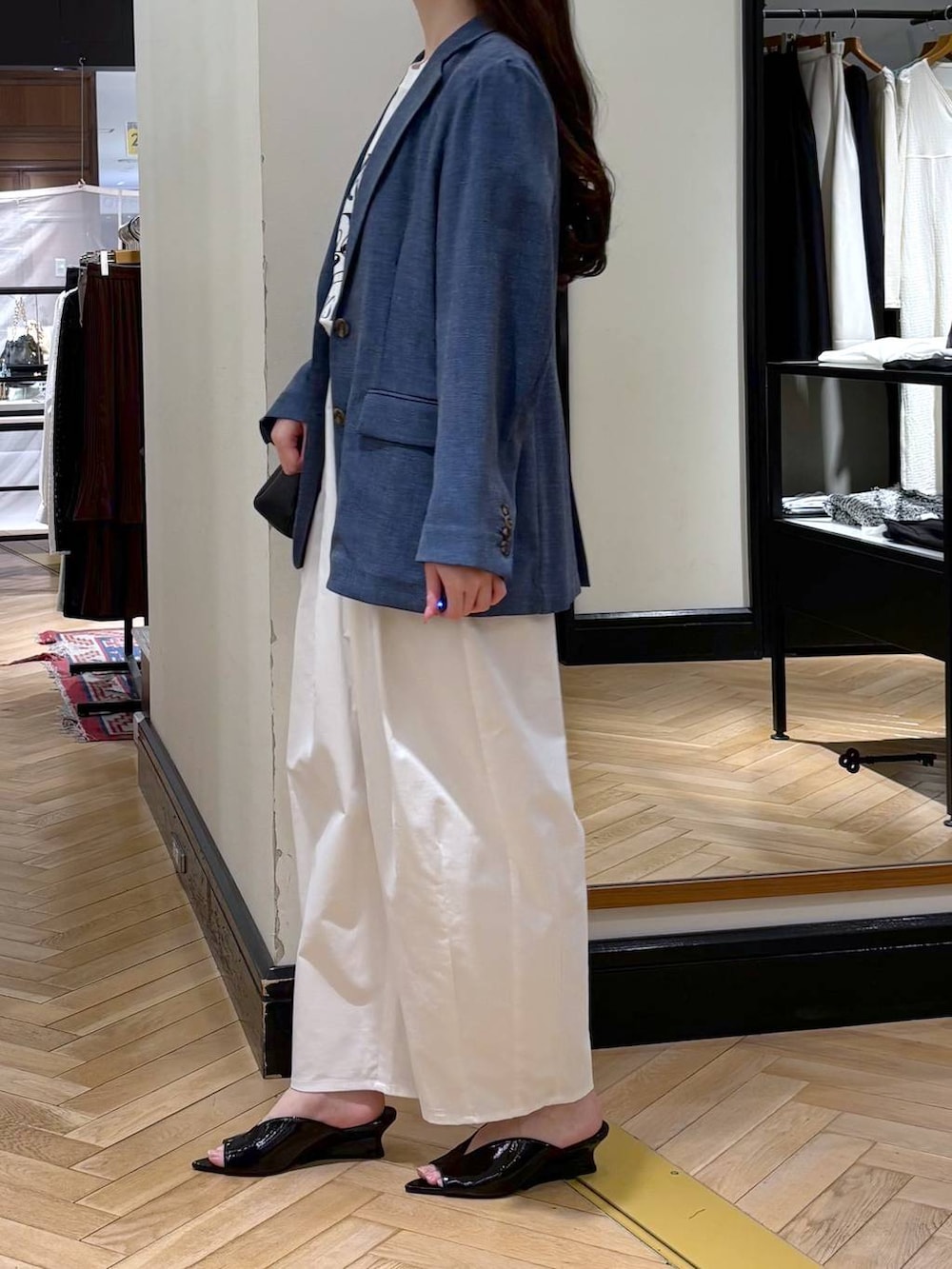 ブルー系のノーカラージャケット、ブラック系のショルダーバッグ、ブラック系のサンダルを着用したレディースの春コーディネートの2枚目の写真