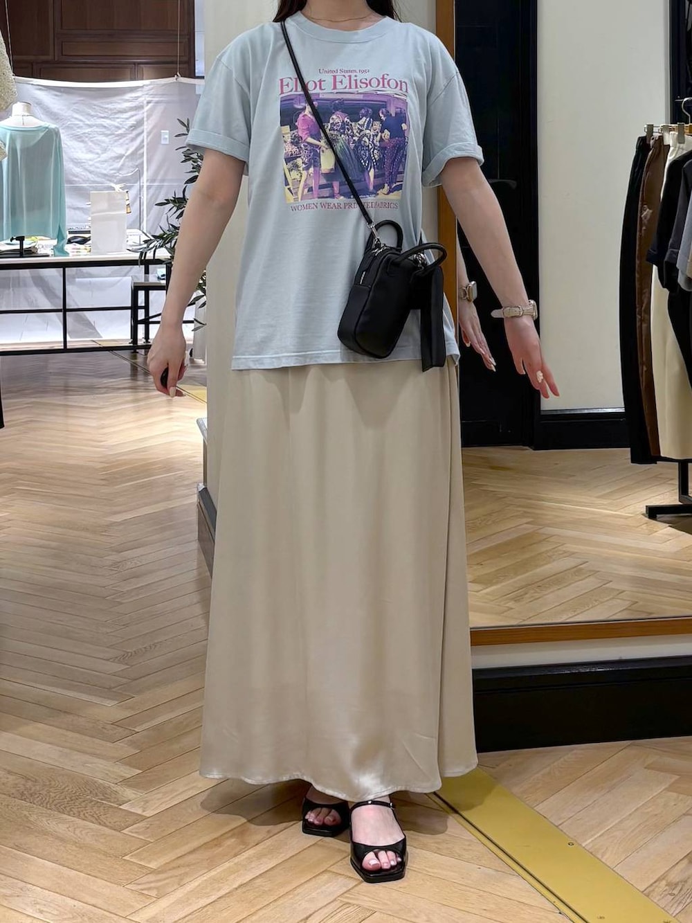 ホワイト系のスカート、ブルー系のTシャツ/カットソー、ブラック系のパンプスを着用したレディースの夏コーディネートの2枚目の写真