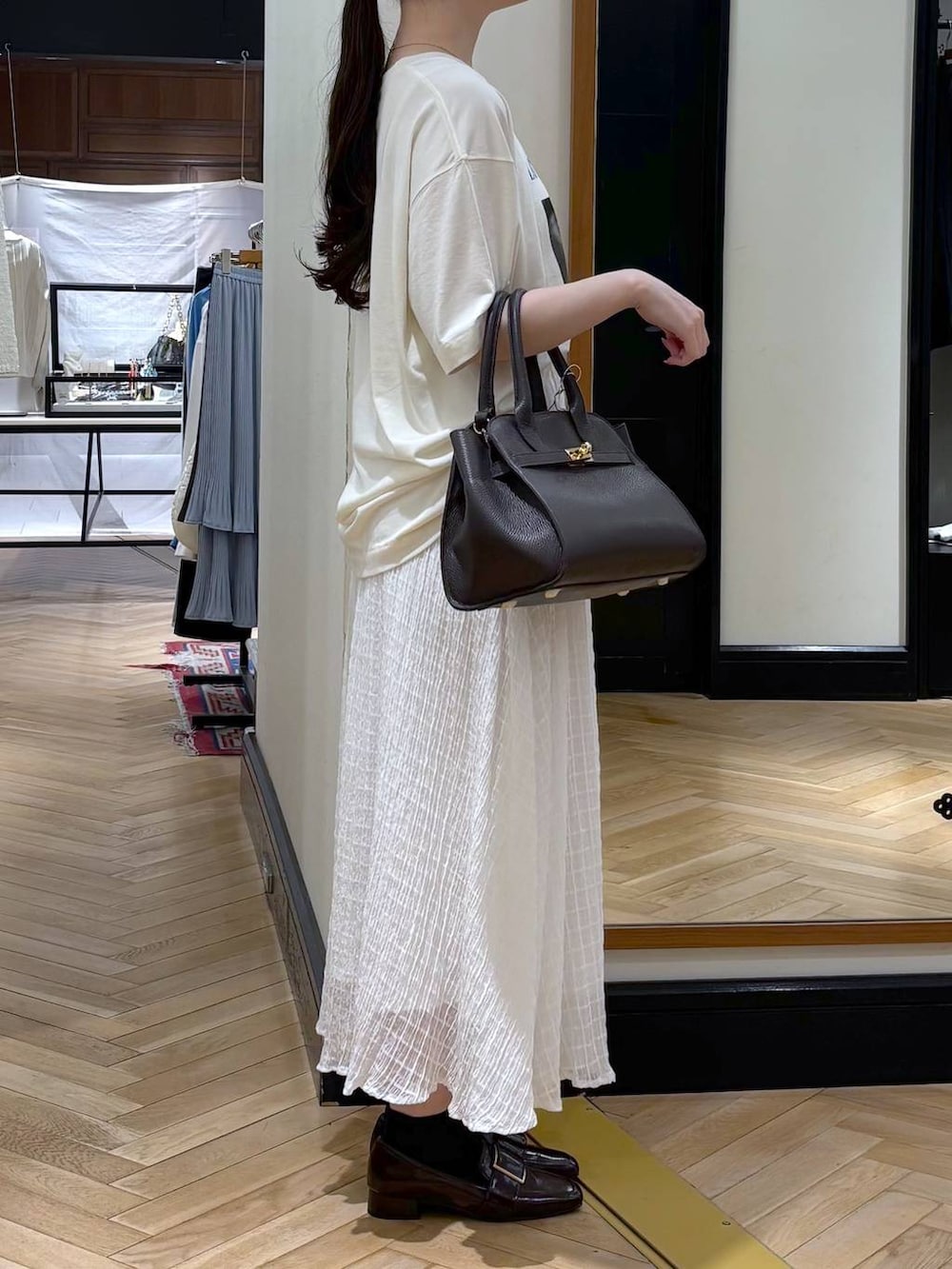 ブラウン系のローファー、ブラック系のショルダーバッグ、ブルー系のTシャツ/カットソーを着用したレディースの春コーディネートの2枚目の写真