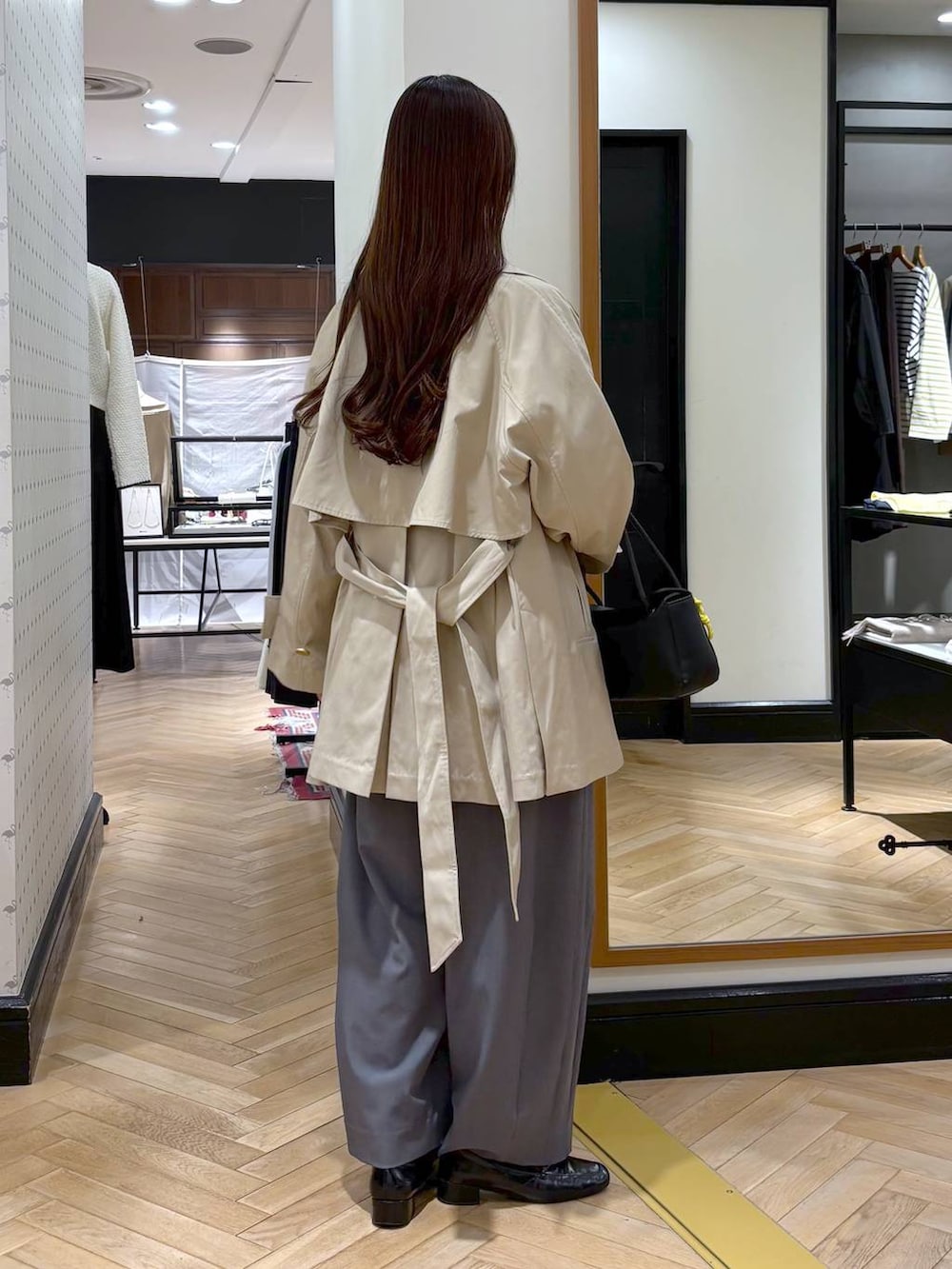 グレー系のスラックス、ブラック系のローファー、ホワイト系のシャツ/ブラウスを着用したレディースの冬コーディネートの7枚目の写真