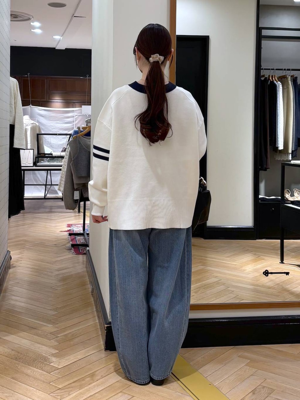 ブルー系のデニムパンツ、ブラック系のカーディガン/ボレロ、ブラック系のショルダーバッグを着用したレディースの冬コーディネートの5枚目の写真