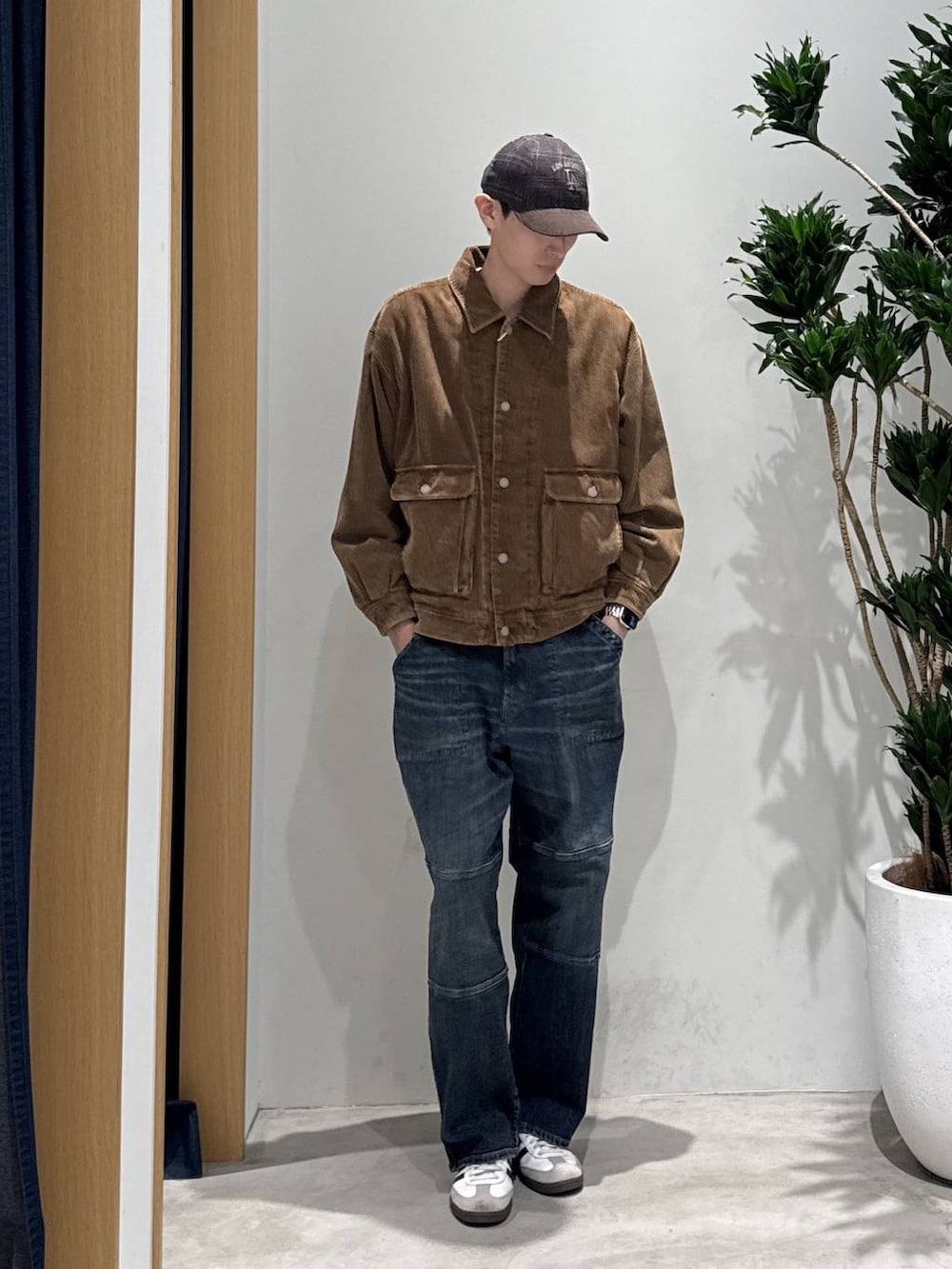 ブラウン系のブルゾン、ブルー系のその他パンツ、ホワイト系のスニーカーを着用したメンズの秋コーディネートの2枚目の写真