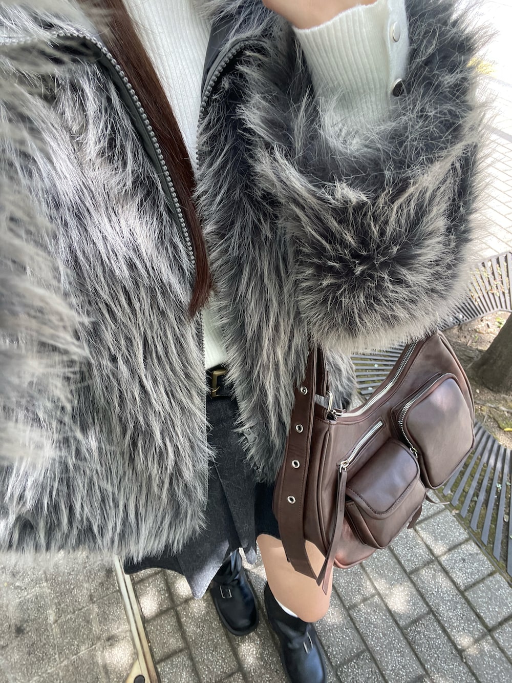 グレー系のブルゾン、ホワイト系のニット/セーター、ブラウン系のショルダーバッグを着用したレディースの秋コーディネートの2枚目の写真