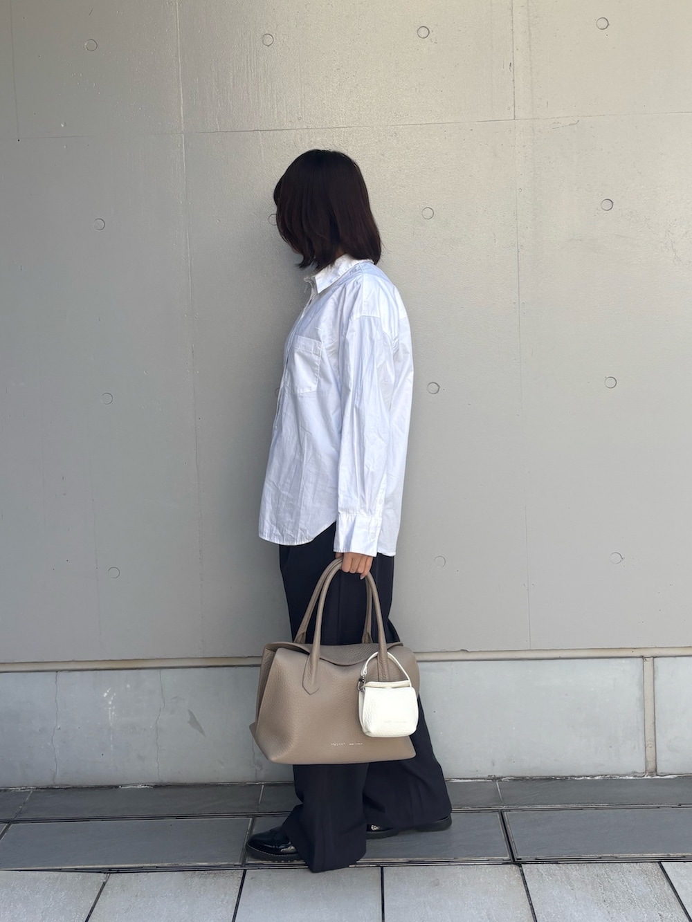 ベージュ系のボストンバッグ、ホワイト系のその他小物を着用したレディースの春コーディネートの2枚目の写真