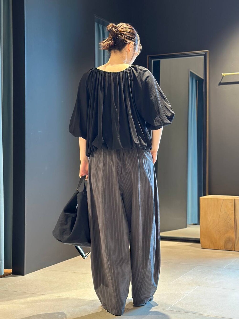 ブラック系のトートバッグ、グレー系のその他パンツ、ブラック系のTシャツ/カットソーを着用したレディースの春コーディネートの3枚目の写真