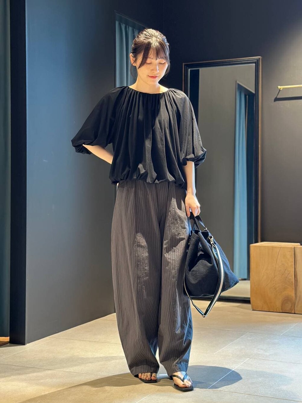 ブラック系のトートバッグ、グレー系のその他パンツ、ブラック系のTシャツ/カットソーを着用したレディースの春コーディネートの4枚目の写真
