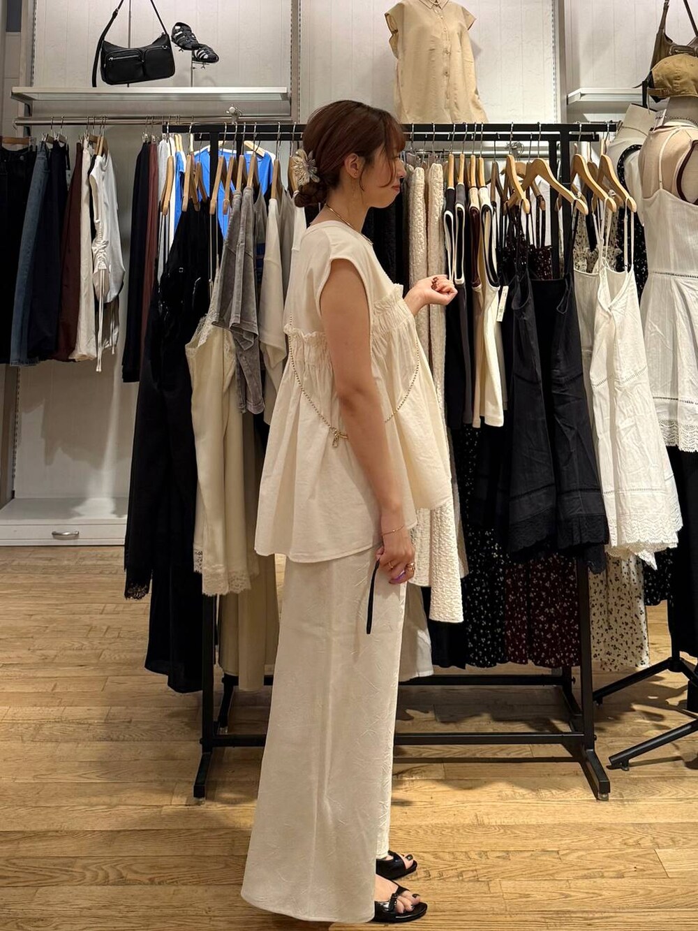 ホワイト系のスカート、ホワイト系のTシャツ/カットソー、ブラック系のサンダルを着用したレディースの夏コーディネートの4枚目の写真