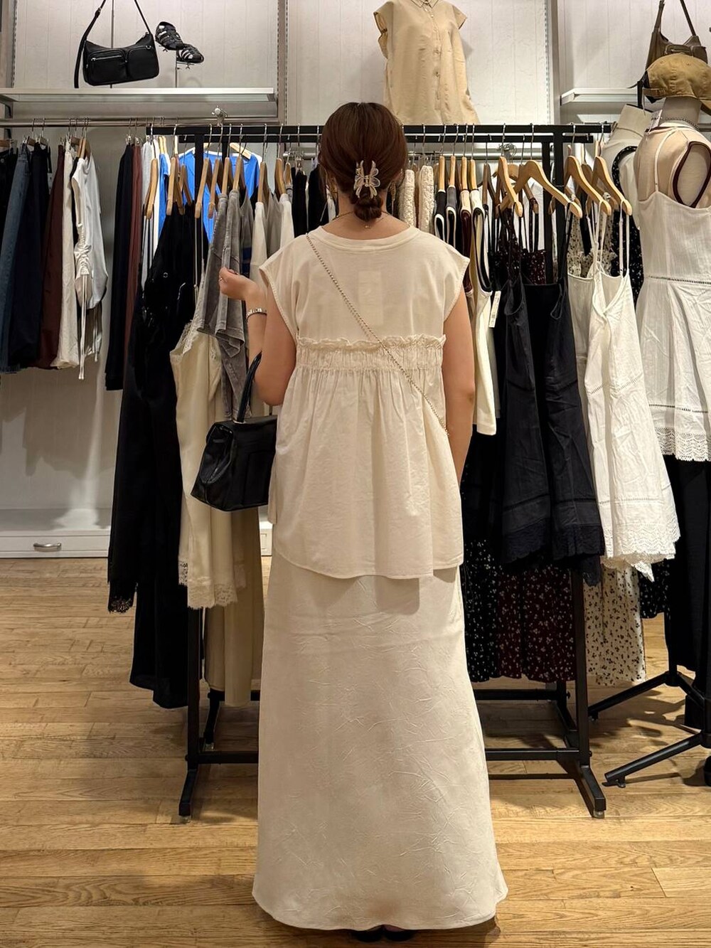 ホワイト系のスカート、ホワイト系のTシャツ/カットソー、ブラック系のサンダルを着用したレディースの夏コーディネートの3枚目の写真