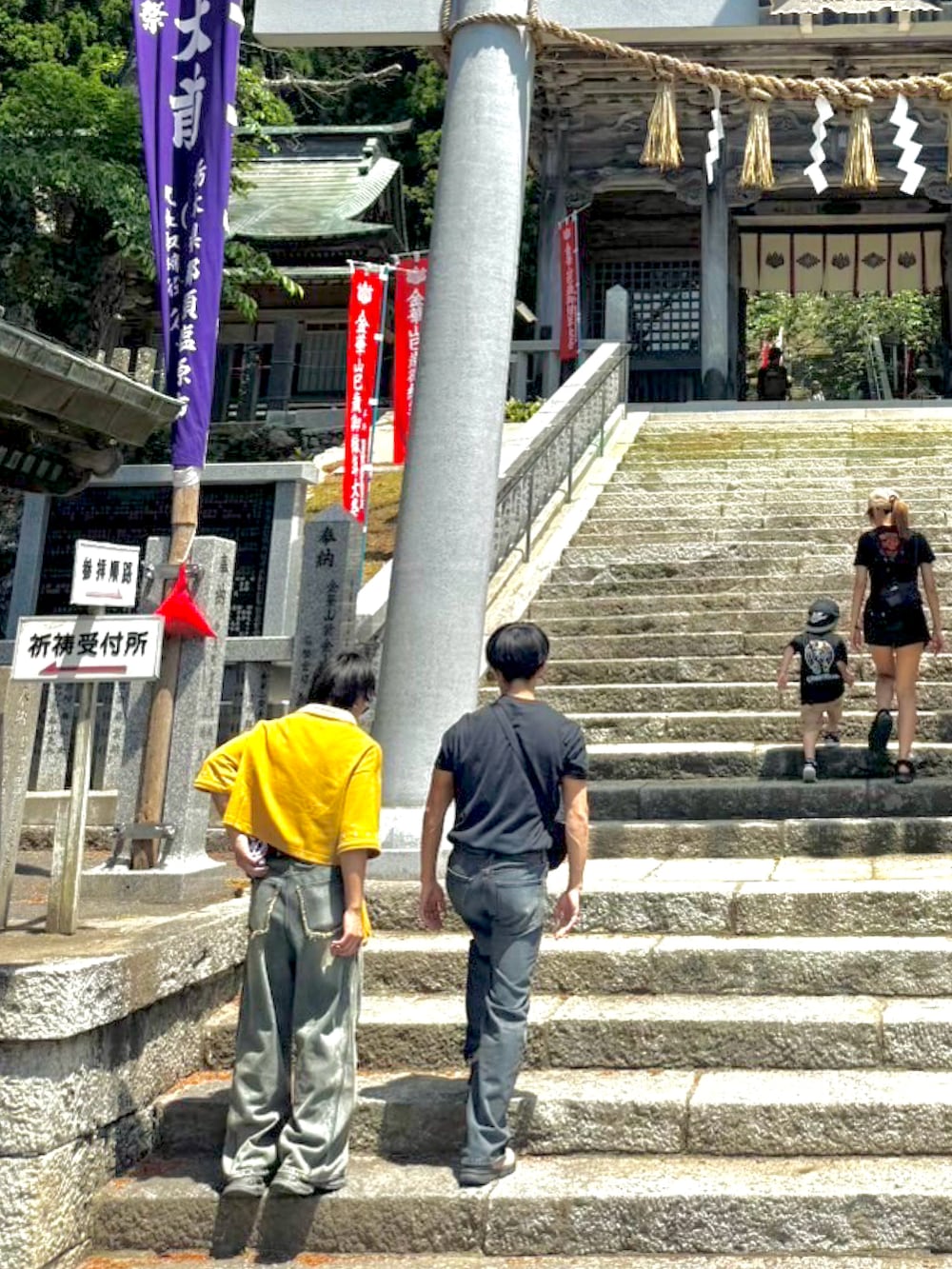 イエロー系のポロシャツ、ブルー系のデニムパンツ、グレー系のスニーカーを着用したメンズの夏コーディネートの2枚目の写真