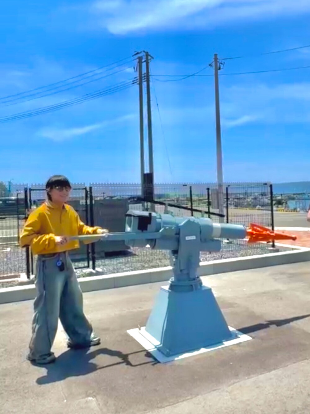 イエロー系のポロシャツ、ブルー系のデニムパンツ、グレー系のスニーカーを着用したメンズの夏コーディネートの3枚目の写真