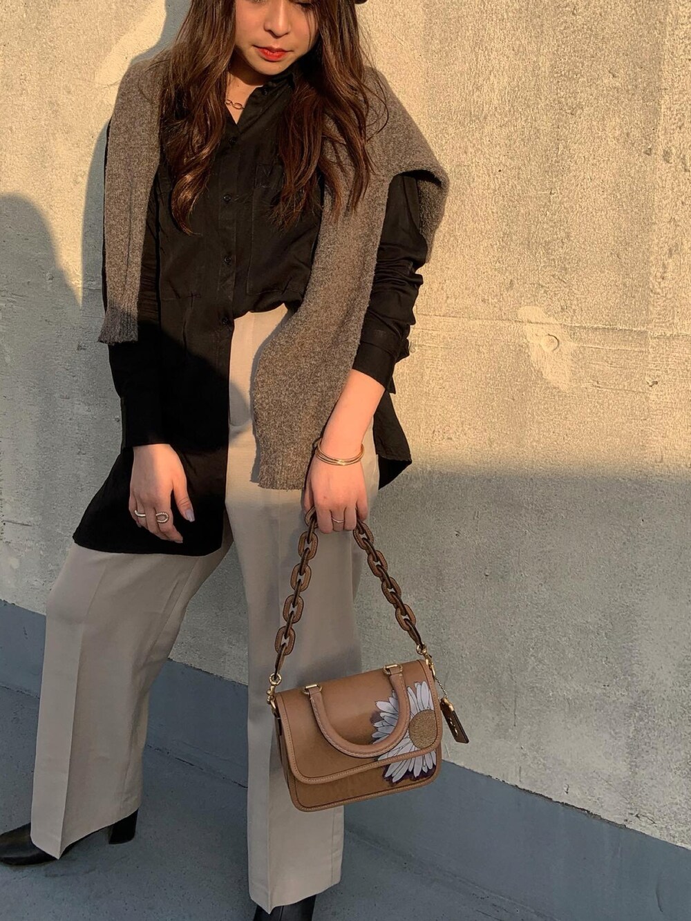 ブラウン系のショルダーバッグ、ブラック系のシャツ/ブラウスを着用したレディースの春コーディネートの3枚目の写真