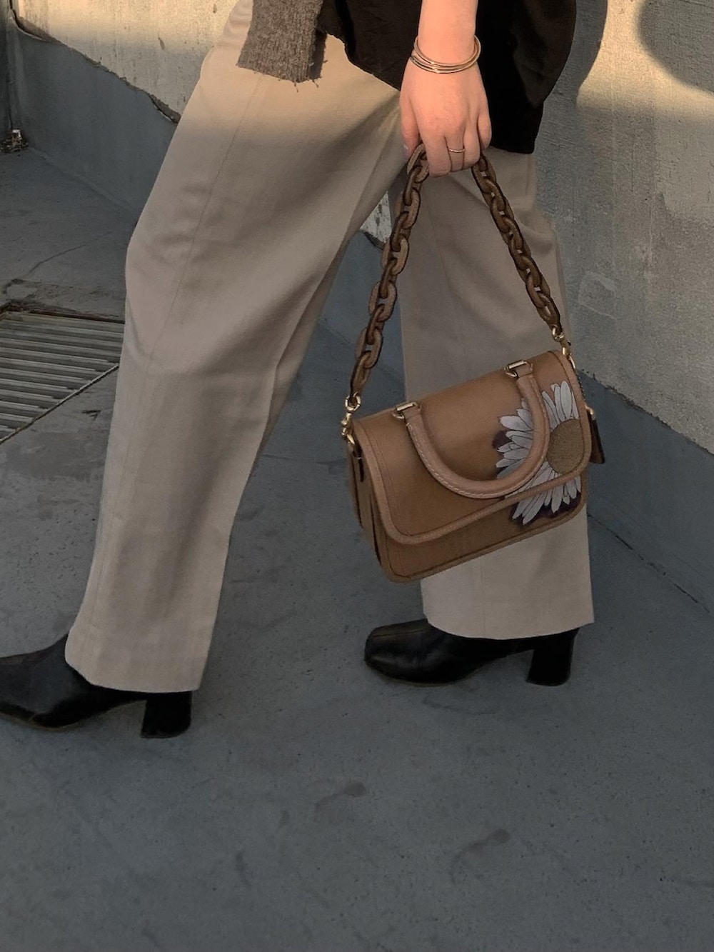 ブラウン系のショルダーバッグ、ブラック系のシャツ/ブラウスを着用したレディースの春コーディネートの2枚目の写真